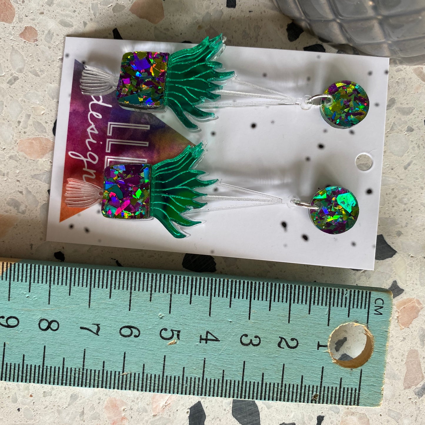 Hanging Planter Dangle Earrings. Featuring Stunning Purple and Green Holographic Planters Hung from Matching Circular Tops.