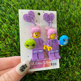 Pink Haired Cutie Brick Character With Purple Bunny Onesie Dangle Earrings With Plushies - Featuring Purple Glitter Heart Shaped Tops!
