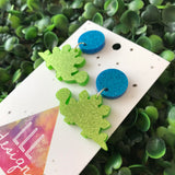 Stegosaurus Statement Dangle Earrings. Glitter Dino Dangles will always Brighten your day! Get your Groove on with this Glittery Guys!!