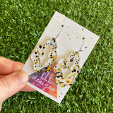 Stunning Clear Wiggle Jiggle Drops featuring Polka Dot Confetti Scattered Throughout. Creating a beautiful visual effect. (Gold/White/Black).