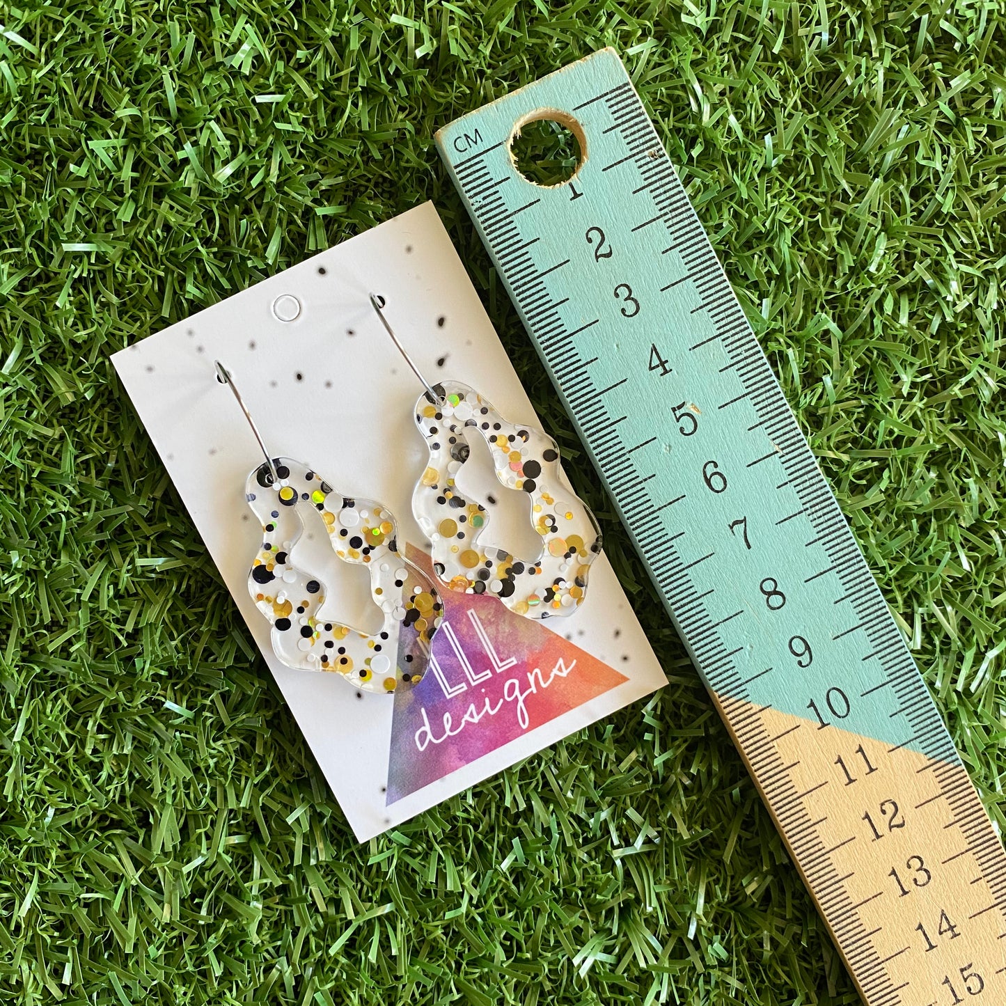 Stunning Clear Wiggle Jiggle Drops featuring Polka Dot Confetti Scattered Throughout. Creating a beautiful visual effect. (Gold/White/Black).