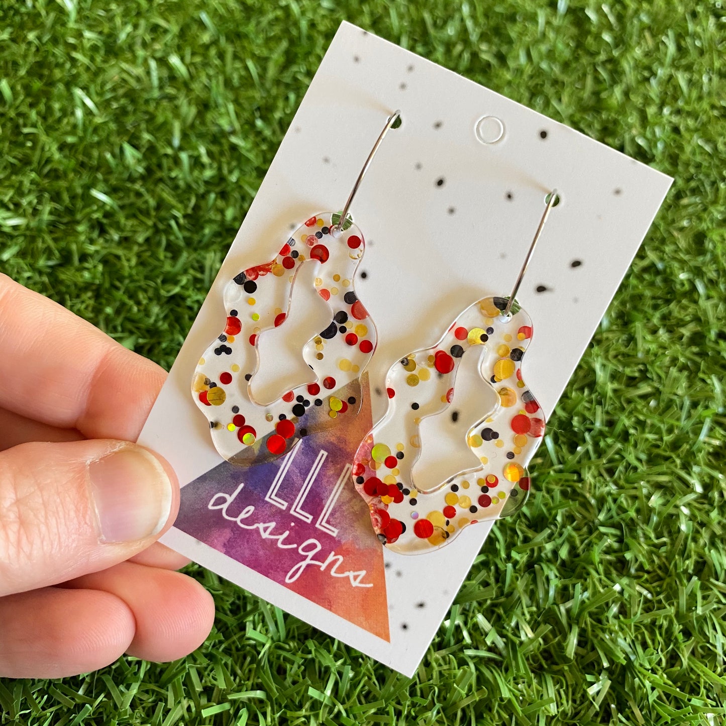 Stunning Clear Wiggle Jiggle Drops featuring Polka Dot Confetti Scattered Throughout. Creating a beautiful visual effect. (Gold/Red/Black).