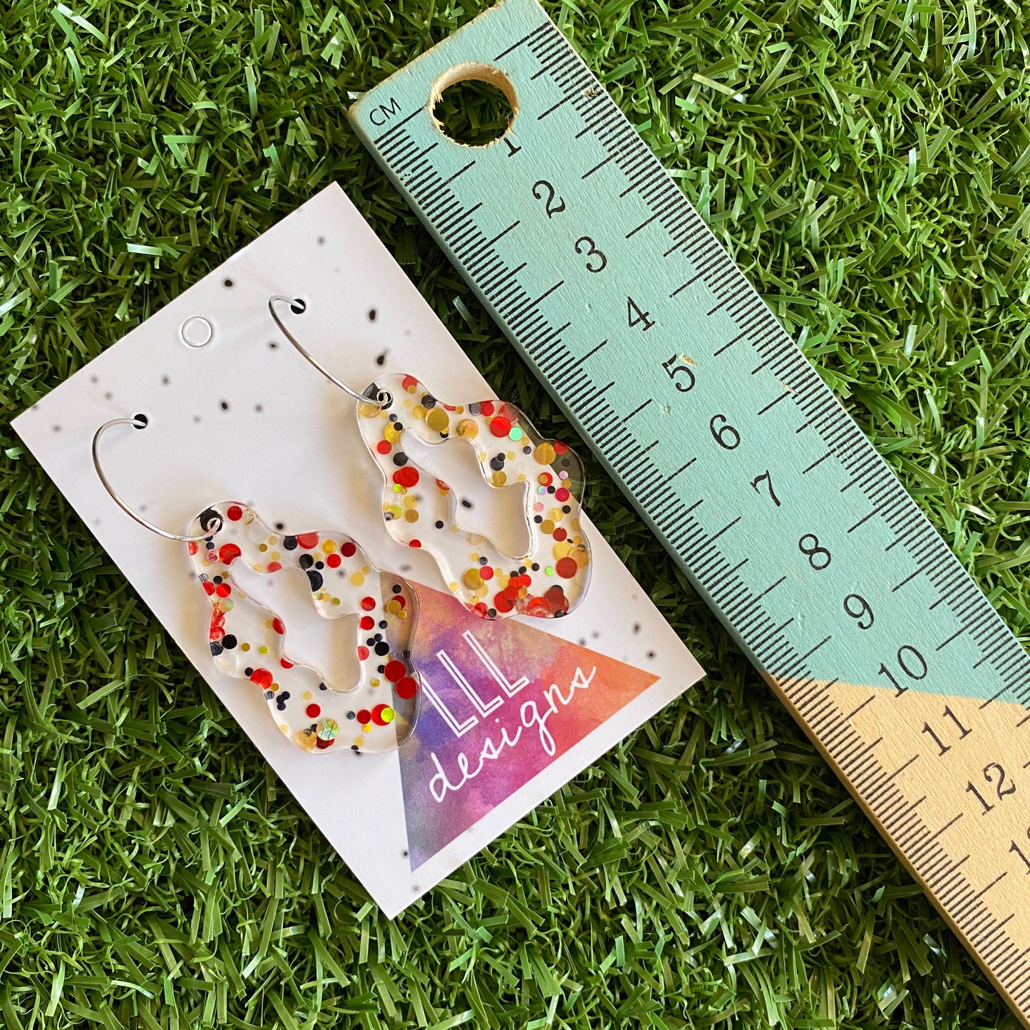 Stunning Clear Wiggle Jiggle Drops featuring Polka Dot Confetti Scattered Throughout. Creating a beautiful visual effect. (Gold/Red/Black).