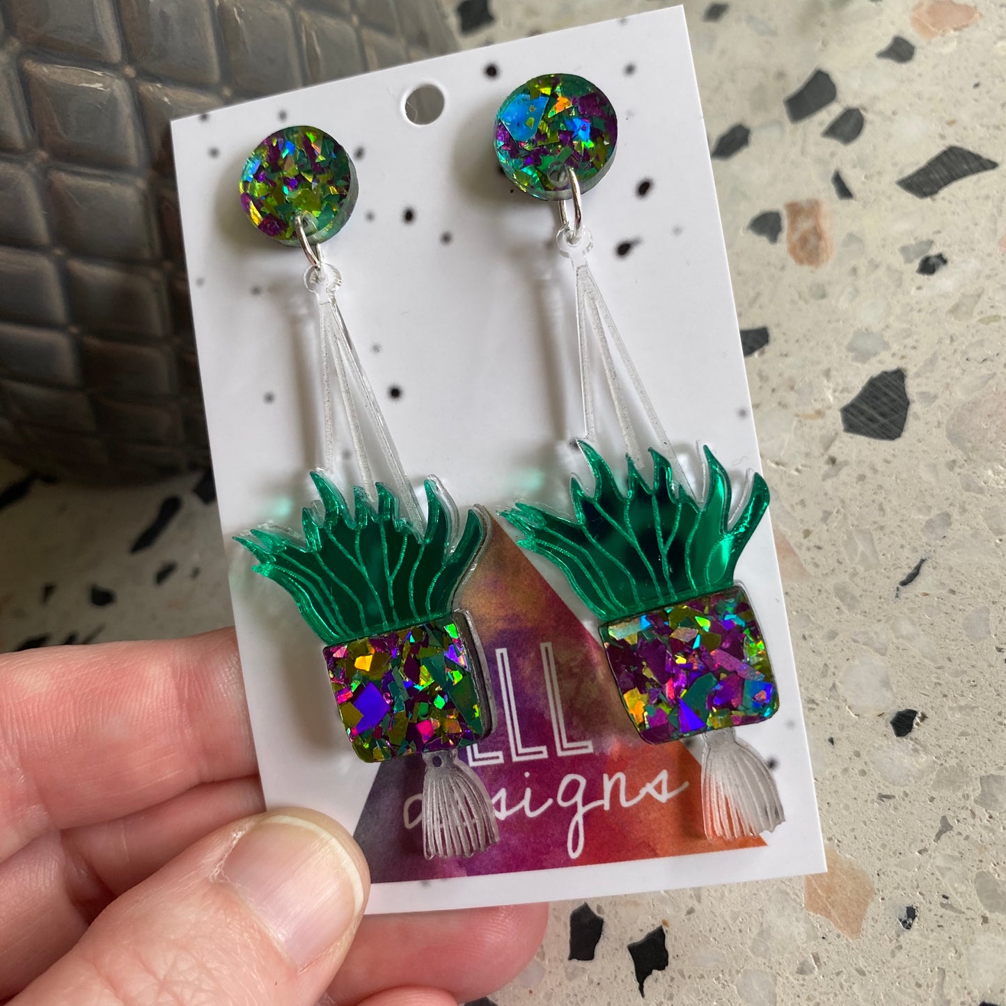 Hanging Planter Dangle Earrings. Featuring Stunning Purple and Green Holographic Planters Hung from Matching Circular Tops.